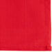 A red cloth napkin with a white stitched edge.