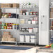 A Regency stainless steel shelving unit in a school kitchen with food on the shelves.