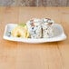 A Thunder Group Blue Bamboo rectangular melamine plate with sushi on it.