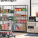 Regency black wire shelving unit with shelves of beverages and boxes in a convenience store.