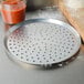 An American Metalcraft perforated pizza pan with a metal tray on top of it.
