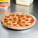 An American Metalcraft perforated pizza pan with a pepperoni pizza on it.