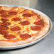 An American Metalcraft perforated aluminum pizza pan with a pepperoni pizza on it.