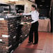 A woman in a restaurant setting using a red rubber anti-fatigue runner mat to carry a tray of food.