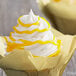 A cupcake with Satin Ice Yellow Vanilla Glitter Glaze yellow swirls on top.