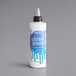 A container of Satin Ice Blue Vanilla Glitter Glaze with a white bottle and black cap.