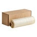 A roll of Western Plastics clear plastic wrapping material next to a box.