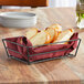 An American Metalcraft black rectangular grid basket filled with sliced bread on a table.