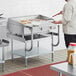 A man cooking food on a stainless steel Cooking Performance Group griddle over a stainless steel counter.