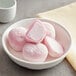 A close-up of a bowl of pink and white My/Mochi ice cream.