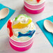 A close up of two small cups of ice cream with Kervan Gummy Sharks on top.