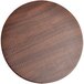 A Spring USA faux wood round riser tray with a textured surface on a table.