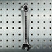 A Triton stainless steel LocHook with a 30 degree bend holding a wrench on a metal pegboard.