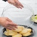 A person holding a clear plastic container of cookies.