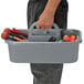 A man holding a gray Quantum tool caddy filled with tools.