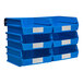 A white louvered panel with blue plastic bins and silver rails filled with white-labeled blue plastic bins.