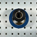 A roll of blue and black tape on a stainless steel LocHook on a metal grid.