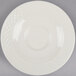 An ivory Homer Laughlin saucer with a circular design.