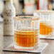 Two glasses of brown liquid with Fee Brothers Molasses Bitters on a table.