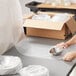 A person wrapping a silver bowl with Pregis bubble wrap.