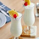 Two glasses of Port Royal Pineapple Juice with a cherry and pineapple on top.