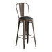A brown metal Lancaster Table & Seating bar stool with a black cushion.
