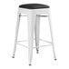 A white metal Lancaster Table & Seating backless counter height stool with a black seat.