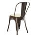 A brown metal Lancaster Table & Seating cafe chair with a white cushion.