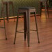 Three Lancaster Table & Seating copper backless bar stools with black vinyl cushions.