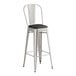 A Lancaster Table & Seating metal barstool with black cushion.