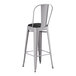 A Lancaster Table & Seating gray metal cafe barstool with black cushion.