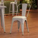 A Lancaster Table & Seating gray metal cafe chair with a white cushion on the seat.