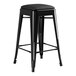 A Lancaster Table & Seating black metal backless counter height stool with a black seat.