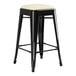 A black Lancaster Table & Seating backless counter height stool with a white square cushion