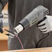 A person using a Genesis dual-temperature heat gun to heat a wooden board.