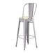 A Lancaster Table & Seating gray metal barstool with a white cushion.