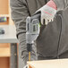 A man using a Genesis 3/8" electric drill to make a wooden box.