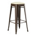 A brown metal Lancaster Table & Seating backless barstool with a white cushion seat.