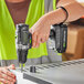 A person using a Genesis cordless drill to make a hole in metal.