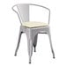A Lancaster Table & Seating gray metal chair with a white cushion.