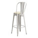 A Lancaster Table & Seating metal barstool with a white cushion.