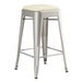 A Lancaster Table & Seating silver metal backless counter height stool with a white cushion on the seat.