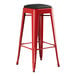 A Lancaster Table & Seating red metal backless barstool with a black cushion.