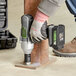 A person using the Genesis 20V Lithium-ion impact wrench to fix a metal pole.