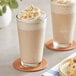 A glass of Frozen Bean Sea Salt Caramel Latte with whipped cream and caramel topping.