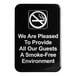 A black sign with white text that says "We Are Pleased To Provide All Our Guests A Smoke-Free Environment"