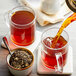 A glass mug filled with brown Davidson's Organic Ginger Peach loose leaf tea.