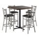 A bar height table set with a square butcher block top in espresso finish and four steel cross back chairs with black vinyl seats.