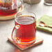 A glass mug of brown Davidson's Organic Irish Breakfast tea with a spoon in it.