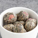A bowl of round green tea blooms.